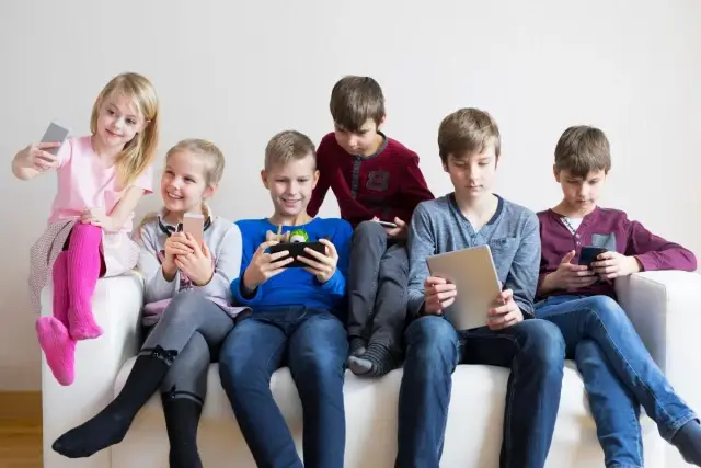 Dzieci na kanapie grają na telefonach i tabletach. Może szukają, jak wyłączyć nadzór rodzicielski bez usuwania konta?