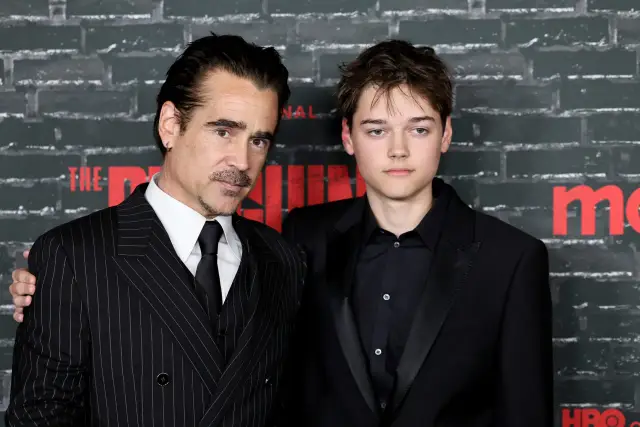 Colin Farrell i jego syn, Barry Keoghan, pozują do zdjęć. Colin ma na sobie prążkowany garnitur, a jego syn czarny smoking.
