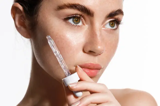 Kwas salicylowy na co? Delikatna skóra z piegami, aplikacja serum z pipetki.