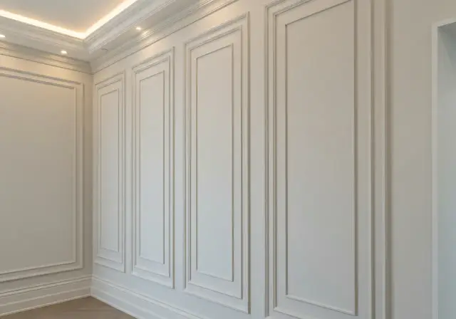 Elegancka sztukateria na ścianie tworzy subtelne wzory, dodając wnętrzu klasy.