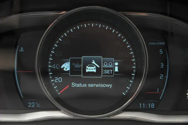 Wyświetlacz Volvo XC60 pokazuje komunikaty ostrzegawcze: status serwisowy, ikonę klucza, reset i informację.