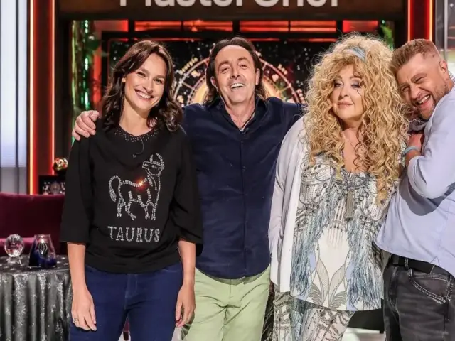 Trzech jurorów MasterChef: uśmiechnięta kobieta w koszulce z bykiem, mężczyzna w granatowej koszuli i kobieta z burzą blond loków.