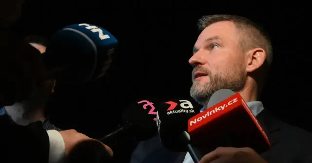 Prezydent Słowacji udziela wywiadu, otoczony przez mikrofony mediów, w tym Novinky.cz.