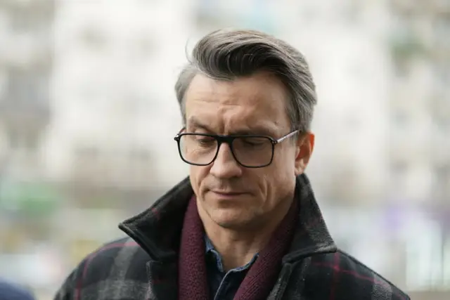 Michał Czernecki w okularach, w płaszczu w kratę i bordowym szaliku. Może to zapowiedź nowego romansu?