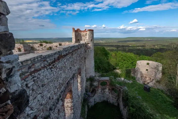 Ruiny zamku Tenczyn zapraszają na zwiedzanie. Majestatyczne mury i wieże wznoszą się na wzgórzu, oferując widok na zielone doliny.