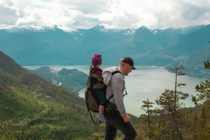 Ojciec z dzieckiem w nosidle na tle gór. Gdzie w Tatry? To pytanie zadaje sobie wielu, ale ten widok zapiera dech w piersiach.