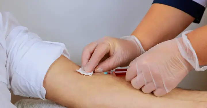 Pielęgniarka pobiera krew do strzykawki. Warto zadbać o odpowiedni poziom hemoglobiny przed oddaniem krwi, by pomóc innym.