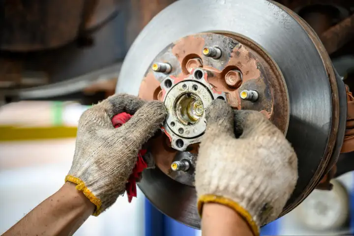 Mechanik sprawdza piastę koła, która może być przyczyną objawów zużytego łożyska koła: huczenie w zakrętach.