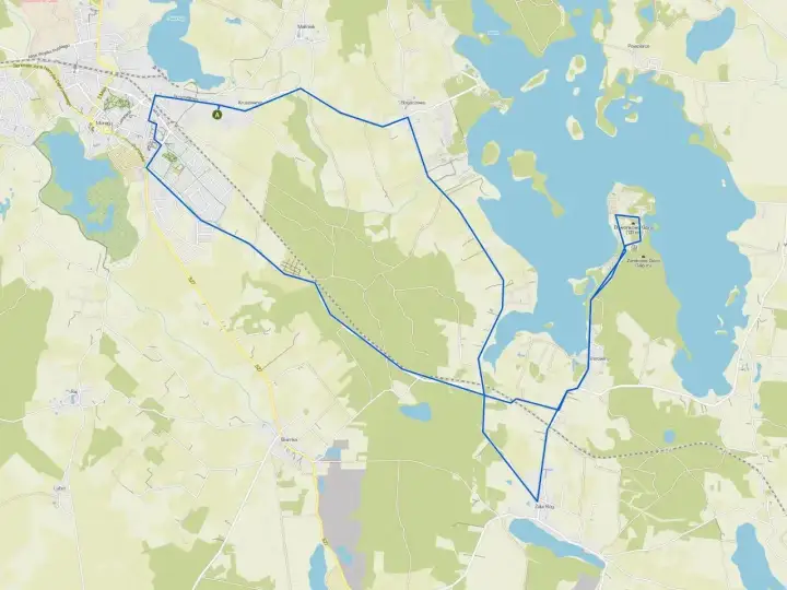 Mapa turystyczna z zaznaczoną trasą wokół miasta nad jeziorem Skiertąg. Widoczne jezioro, lasy i zabudowania.