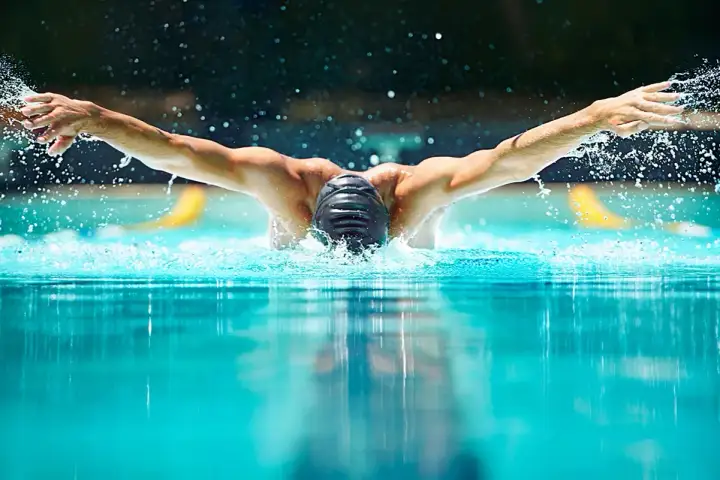 Swimmer performing butterfly stroke, showcasing the power and fluidity needed for mobility exercises for swimmers.