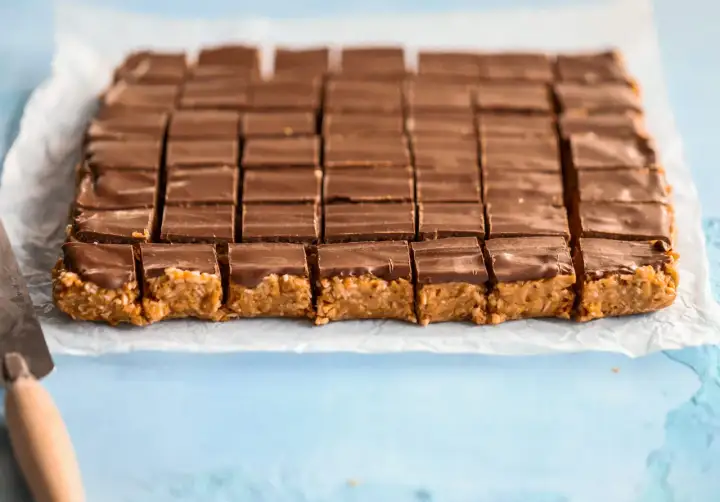 En hel plåt med chokladöverdragna bitar, redo att avnjutas. Ett perfekt snickerskaka recept för fikat.