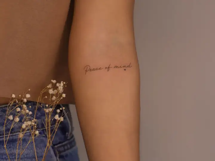 Brazo con tatuaje de "Peace of mind", un recordatorio constante de la paz interior.