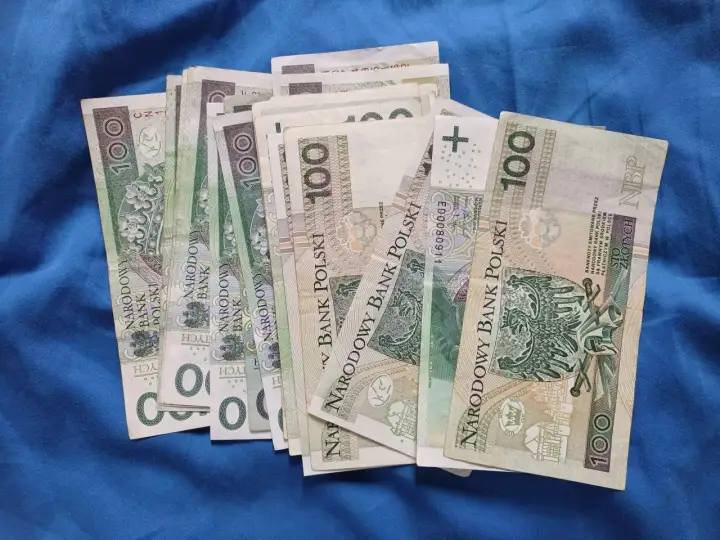 Stos stu-złotowych banknotów. Zastanawiasz się, ile można przelać z konta dziecka?