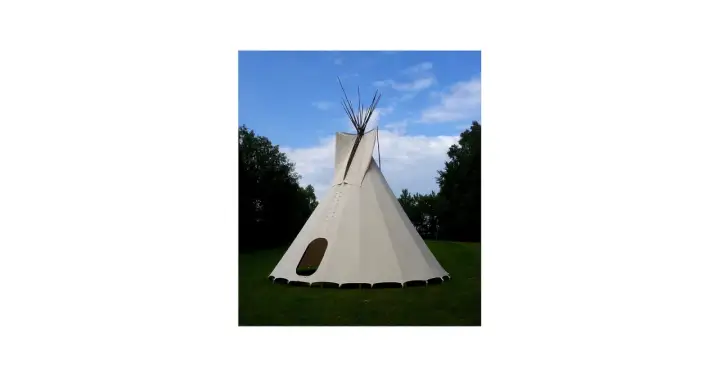 Gotowe tipi ze stabilizatorem, gotowe do rozłożenia na trawie, pod błękitnym niebem.