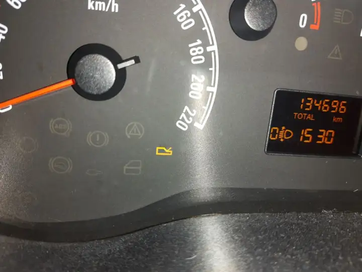 Kontrolki w Oplu: ABS, hamulec, poduszka, drzwi, bagażnik. Na wyświetlaczu przebieg 134696 km i czas 15:30.