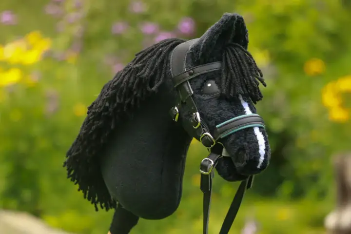 Czarny koń na kiju z czarną grzywą i ozdobnym ogłowiem dla hobby horse.