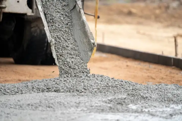 Betoniarka wylewa świeży beton na plac budowy.