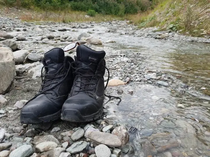 Czarne buty Magnum na kamienistym brzegu potoku. Złe buty na śliskich bazaltach Gór Kaczawskich to gwarancja mokrych stóp i nieprzyjemnych przygód.