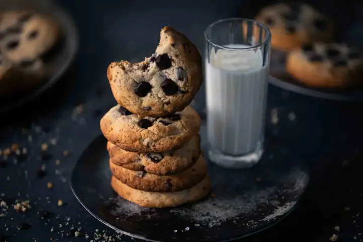 Ein Stapel saftiger American Cookies mit Schokoladenstückchen, daneben ein Glas Milch. Perfekt für das American Cookies Rezept.