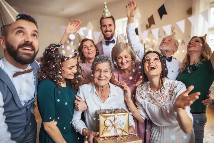 Rodzina świętuje 50 lat ślubu, sypiąc konfetti. Eleganckie stroje, jak na taką okazję, podkreślają radość.