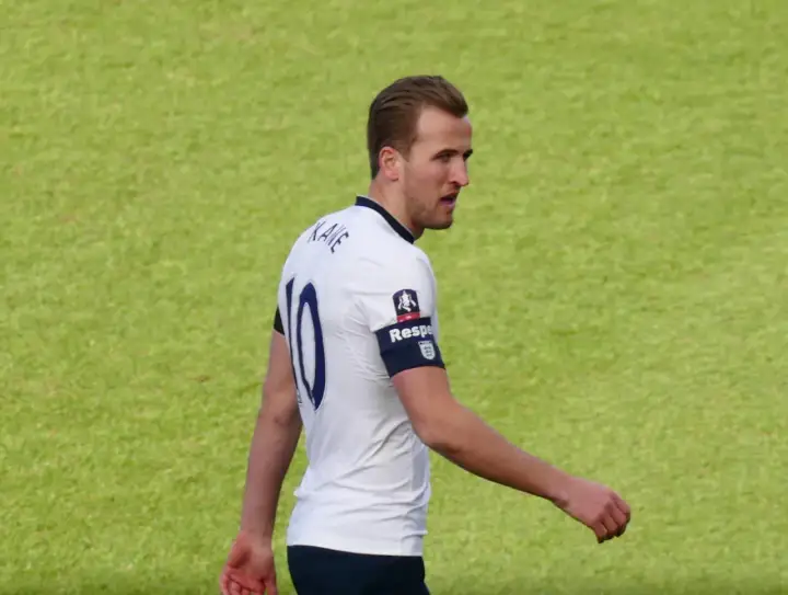 Piłkarz Harry Kane w białej koszulce z numerem 10. Zastanawiasz się, ile lat ma Harry Kane?