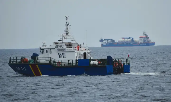 Kuter Straży Granicznej "PATROL 1" płynie po morzu. W tle widać duży statek "Van Oord".