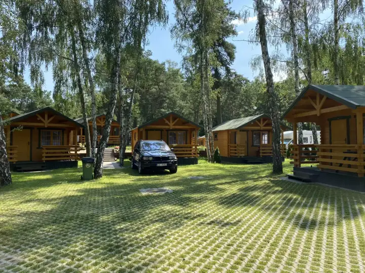 Urokliwe domki nad morzem w Gdańsku, otoczone zielenią i drzewami. Idealne miejsce na wakacyjny wypoczynek.