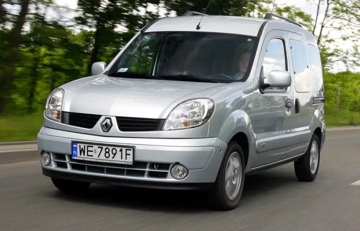 Srebrny Renault Kangoo 1.5 dCi jedzie po drodze wśród zieleni.