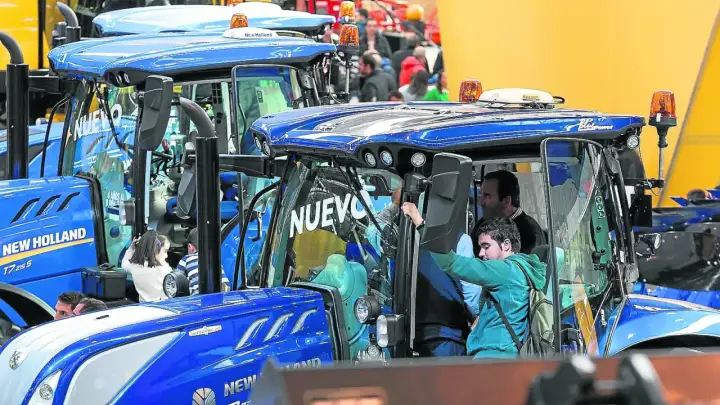 Tractores New Holland en la FIMA Zaragoza 2026. Personas observan los nuevos modelos, algunos niños curiosos se asoman.