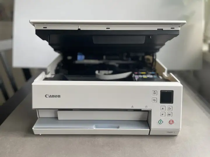 Drukarka Canon TS6351 z otwartą klapą, gotowa do drukowania. Dowiedz się, jak połączyć drukarkę Canon z telefonem, by drukować bezprzewodowo.