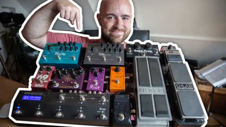 Uśmiechnięty mężczyzna pokazuje swoją bogatą kolekcję efektów gitarowych, prezentując ich kolejność na pedalboardzie.