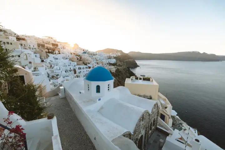 Ein malerischer Blick auf Oia, Santorini, mit seinen weiß getünchten Häusern und der ikonischen blauen Kuppelkirche. Perfekt für einen Santorini Urlaub.