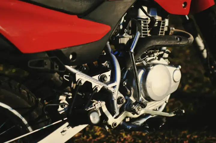 Silnik motocykla z czerwonym siedzeniem. Zastanawiasz się, świece irydowe co ile wymiana?