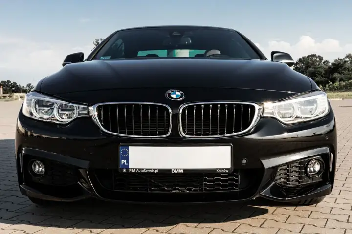 Czarny BMW F32 435i z błyszczącą atrapą chłodnicy i ostrymi reflektorami, gotowy do jazdy po krakowskich ulicach.