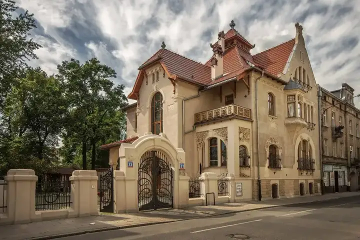 Elegancka willa w stylu secesja Młoda Polska, z bogatymi zdobieniami i kutą bramą.