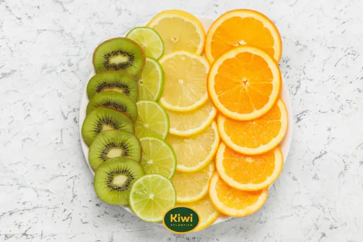 Rodajas de kiwi, limón y naranja en un plato. El kiwi es cítrico, aportando un toque ácido a esta colorida selección de frutas.