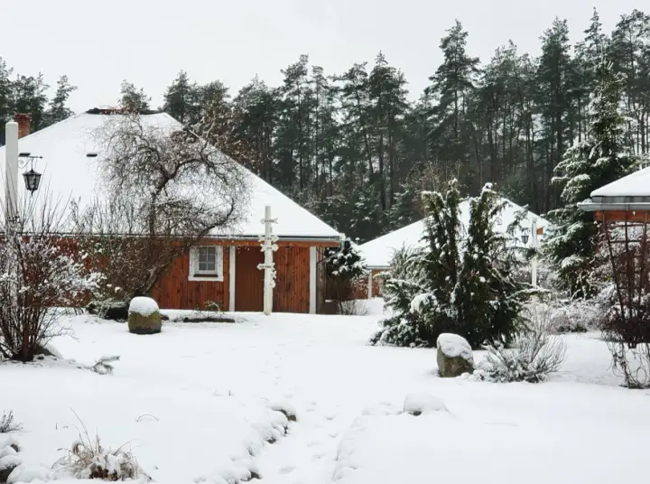 Śnieżne Boże Narodzenie na Kaszubach. Drewniane domki agroturystyki otoczone lasem i pokryte białym puchem.