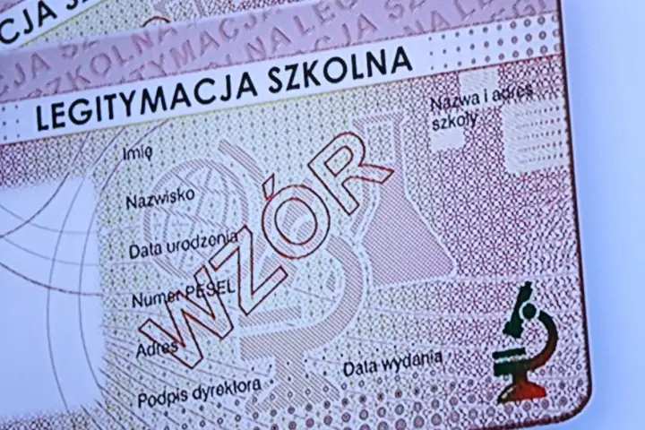 Fragment e-legitymacji szkolnej z napisem "WZÓR". Widoczne pola na dane ucznia i szkoły, a także symbol mikroskopu.