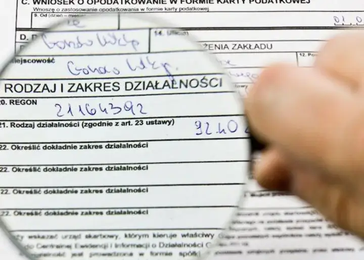 Pod lupą formularz podatkowy, gdzie wpisano dane dotyczące działalności gospodarczej. Może to być związane z wyborem formy opodatkowania, np. podatek liniowy.