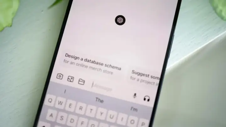 Ekran smartfona z interfejsem czatu AI, klawiaturą i ikoną ChatGPT.