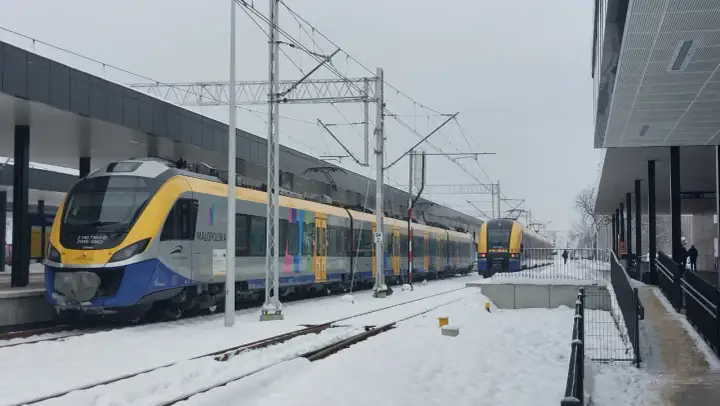 Pociągi PKP na trasie Kraków-Oświęcim przez Skawinę stoją na zaśnieżonej stacji.