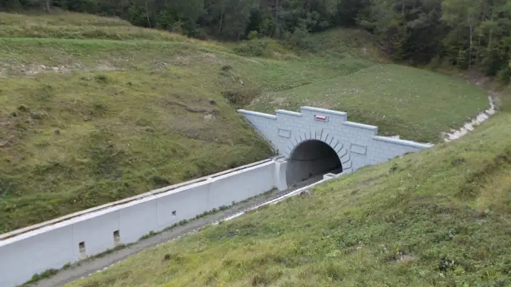 Nowy tunel kolejowy na przełęczy łupkowskiej, wcinający się w zielone zbocze.