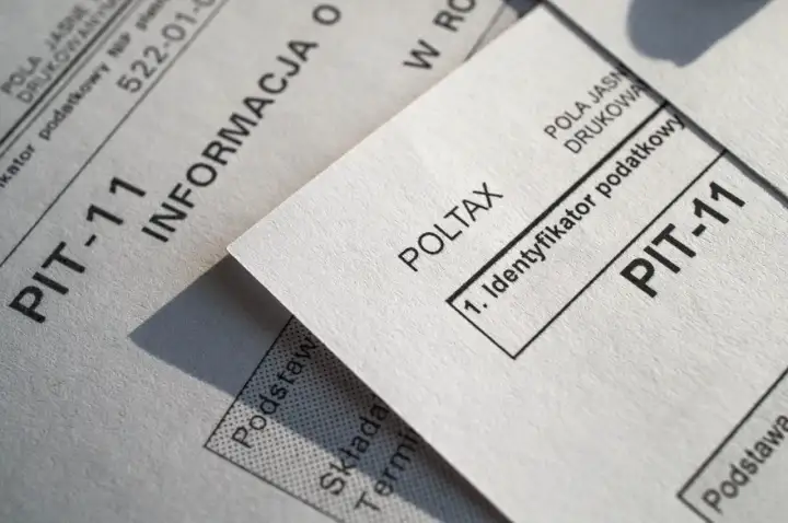 Dokumenty PIT-11 i Poltax, kluczowe dla rezydenta podatkowego, leżą obok siebie.