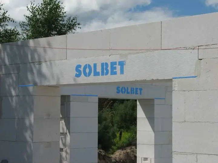 Kształtki wieńcowe Solbet na budowie domu. Elementy konstrukcyjne z widocznym logo producenta.