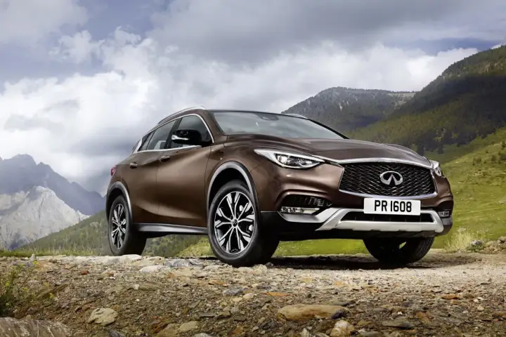 Brązowy Infiniti QX30 na kamienistej drodze w górach.