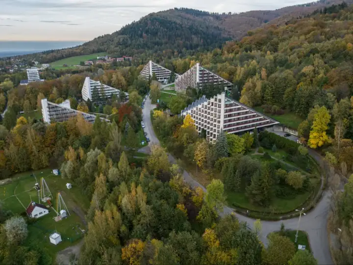 Widok z lotu ptaka na architekturę sanatorium w otoczeniu jesiennego lasu. Zastanawiasz się, ile się dopłaca do sanatorium?