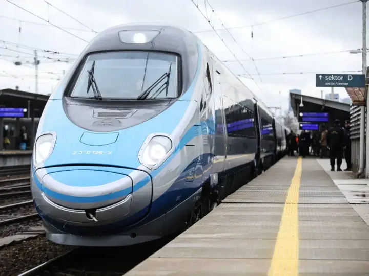 Nowoczesny pociąg PKP na peronie. Pasażerowie czekają na podróż, a Ty zastanawiasz się nad dopłatą do biletu ulgowego PKP.