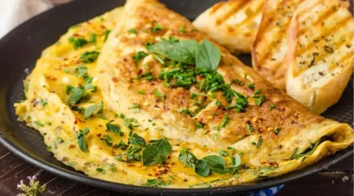 Puszysty omlet bez mąki, posypany szczypiorkiem i płatkami chili, podany z grzankami czosnkowymi. Idealne śniadanie.