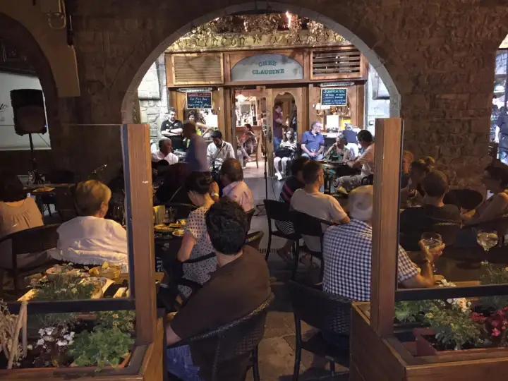 Gente disfrutando en Chez Claudine, uno de los mejores restaurantes Jaca, con música en vivo y ambiente acogedor.