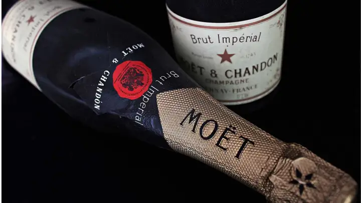 Dwie butelki szampana Moët & Chandon Brut Impérial na czarnym tle. Zastanawiasz się, ile szampan ma procent? Zwykle 12%.
